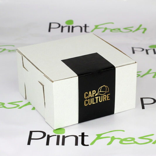 200 Cajas Blancas para Gorras, de Carton Micro Corrugado con Sticker de Cierre. Medidas: 21x21x12 cm.